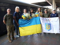 Ukrainian epee fencers Olena Kryvytska (3rd L), Vlada Kharkova (C), and Dzhoan Feybi Bezhura (3rd R) are posing for a photo on the platform...