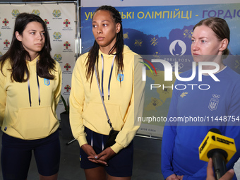 Ukrainian epee fencers Vlada Kharkova, Dzhoan Feybi Bezhura, and Olena Kryvytska (L to R) are answering reporters' questions upon coming bac...