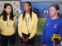 Ukrainian epee fencers Vlada Kharkova, Dzhoan Feybi Bezhura, and Olena Kryvytska (L to R) are answering reporters' questions upon coming bac...