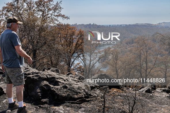 Ken Elmore is standing on his property following the aftermath of the Thompson Fire, in Oroville, Calif., on July 31, 2024. Along with his w...