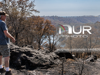 Ken Elmore is standing on his property following the aftermath of the Thompson Fire, in Oroville, Calif., on July 31, 2024. Along with his w...