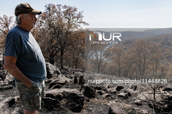 Ken Elmore is standing on his property following the aftermath of the Thompson Fire, in Oroville, Calif., on July 31, 2024. Along with his w...