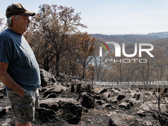 Ken Elmore is standing on his property following the aftermath of the Thompson Fire, in Oroville, Calif., on July 31, 2024. Along with his w...