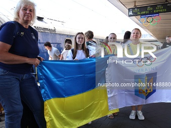 Coach Yuliia Kaiukova (center) and Ukrainian artistic gymnast Anna Lashchevska (second from left) are being pictured during the welcome cere...