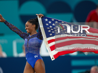 Gold medalist and winner Simone Biles of USA celebrates victory with the USA flag while the women's final all-round competition on day six o...