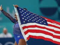 Gold medalist and winner Simone Biles of USA celebrates victory with the USA flag while the women's final all-round competition on day six o...