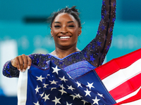 Gold medalist and winner Simone Biles of USA celebrates victory with the USA flag while the women's final all-round competition on day six o...