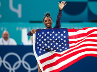 Gold medalist and winner Simone Biles of USA celebrates victory with the USA flag while the women's final all-round competition on day six o...