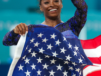 Gold medalist and winner Simone Biles of USA celebrates victory with the USA flag while the women's final all-round competition on day six o...