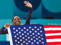 Gold medalist and winner Simone Biles of USA celebrates victory with the USA flag while the women's final all-round competition on day six o...