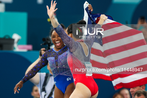 Gold medalist and winner Simone Biles of USA and bronze medalist Suni Lee are celebrating victory with the USA flag while the women's final...