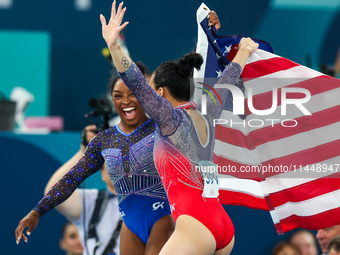 Gold medalist and winner Simone Biles of USA and bronze medalist Suni Lee are celebrating victory with the USA flag while the women's final...