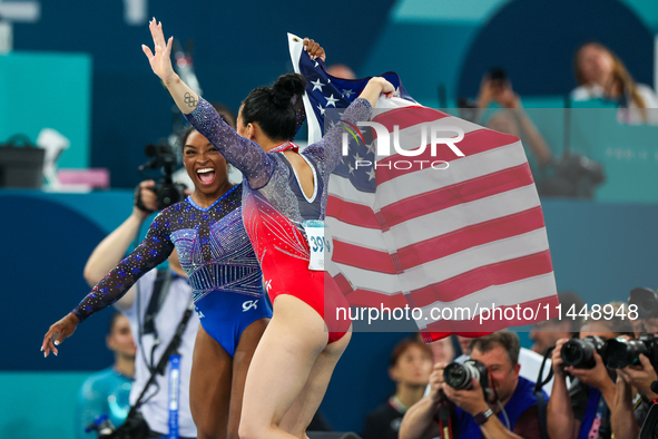 Gold medalist and winner Simone Biles of USA and bronze medalist Suni Lee are celebrating victory with the USA flag while the women's final...