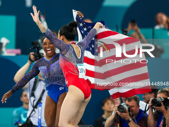 Gold medalist and winner Simone Biles of USA and bronze medalist Suni Lee are celebrating victory with the USA flag while the women's final...