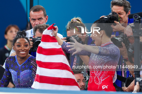 Gold medalist and winner Simone Biles of USA and bronze medalist Suni Lee are celebrating victory with the USA flag while the women's final...