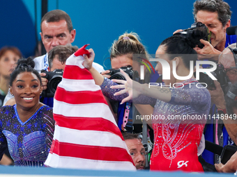 Gold medalist and winner Simone Biles of USA and bronze medalist Suni Lee are celebrating victory with the USA flag while the women's final...