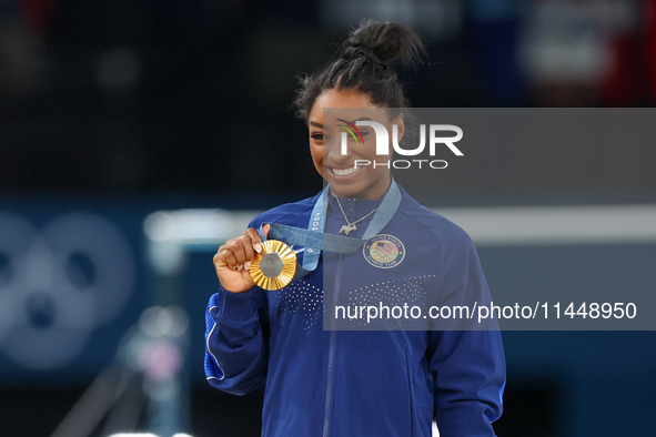 Gold medalist and winner Simone Biles of USA  poses during medal ceremony victory after the women's final all-round competition on day six o...