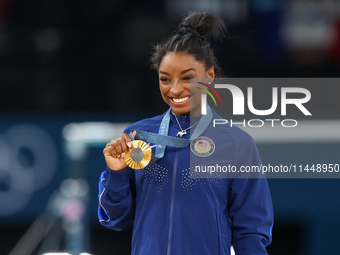 Gold medalist and winner Simone Biles of USA  poses during medal ceremony victory after the women's final all-round competition on day six o...