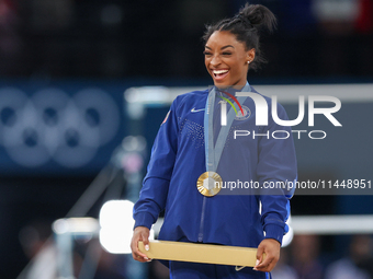 Gold medalist and winner Simone Biles of USA  poses during medal ceremony victory after the women's final all-round competition on day six o...