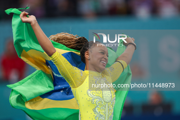 Rebeca Andrade celebrates victory with the Brazilian  flag while the women's final all-round competition on day six of the Olympic Games Par...