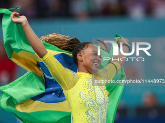 Rebeca Andrade celebrates victory with the Brazilian  flag while the women's final all-round competition on day six of the Olympic Games Par...