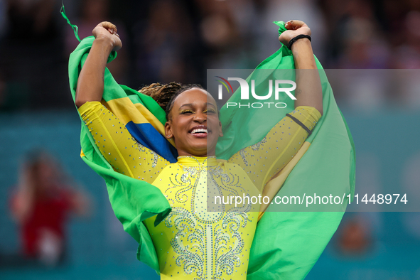 Rebeca Andrade celebrates victory with the Brazilian  flag while the women's final all-round competition on day six of the Olympic Games Par...