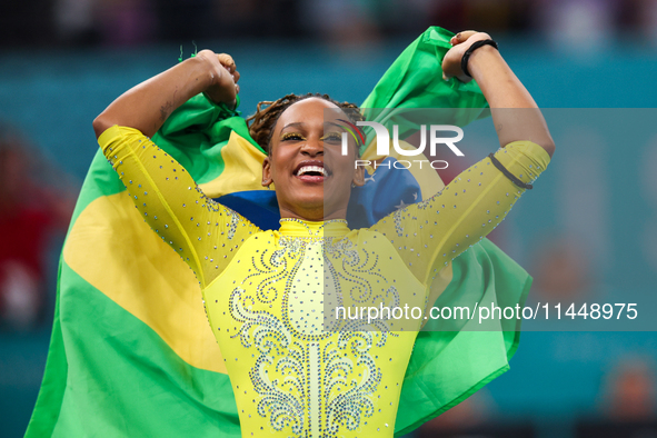 Rebeca Andrade celebrates victory with the Brazilian  flag while the women's final all-round competition on day six of the Olympic Games Par...