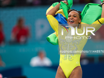 Rebeca Andrade celebrates victory with the Brazilian  flag while the women's final all-round competition on day six of the Olympic Games Par...