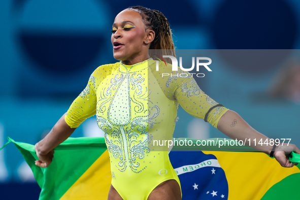 Rebeca Andrade celebrates victory with the Brazilian  flag while the women's final all-round competition on day six of the Olympic Games Par...