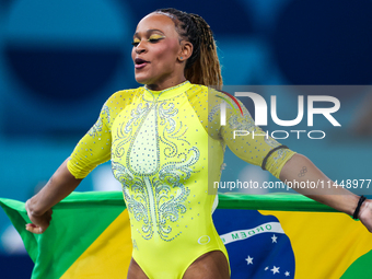 Rebeca Andrade celebrates victory with the Brazilian  flag while the women's final all-round competition on day six of the Olympic Games Par...