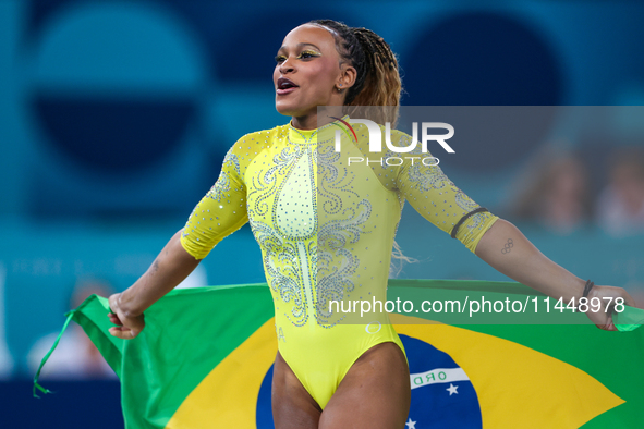 Rebeca Andrade celebrates victory with the Brazilian  flag while the women's final all-round competition on day six of the Olympic Games Par...