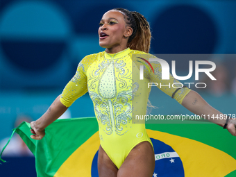 Rebeca Andrade celebrates victory with the Brazilian  flag while the women's final all-round competition on day six of the Olympic Games Par...