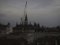 The crane operates near the Vienna City Hall during the evening in Vienna. Austria, Thursday, August 1, 2024. (