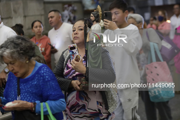 A woman is holding an image of St. Jude Thaddeus at the Church of San Hipolito in Mexico City, Mexico, on August 1, 2024 where dozens of peo...