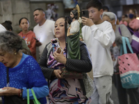 A woman is holding an image of St. Jude Thaddeus at the Church of San Hipolito in Mexico City, Mexico, on August 1, 2024 where dozens of peo...