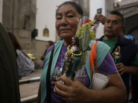 A woman is holding an image of St. Jude Thaddeus at the Church of San Hipolito in Mexico City, Mexico, on August 1, 2024 where dozens of peo...