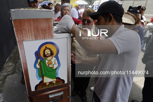 Coins of Saint Jude Thaddeus are being minted outside the Church of San Hipolito in Mexico City, Mexico, on August 1, 2024 where dozens of p...