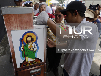 Coins of Saint Jude Thaddeus are being minted outside the Church of San Hipolito in Mexico City, Mexico, on August 1, 2024 where dozens of p...