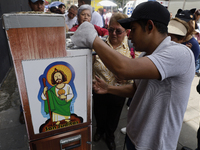 Coins of Saint Jude Thaddeus are being minted outside the Church of San Hipolito in Mexico City, Mexico, on August 1, 2024 where dozens of p...