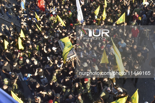 Hezbollah fighters and mourners are attending the funeral ceremony of slain top commander Fuad Shukr in Beirut's southern suburbs, on August...