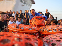 Workers are loading and unloading swimming crabs at the dock of Zhoushan International Aquatic City in Zhoushan, China, on August 2, 2024. (