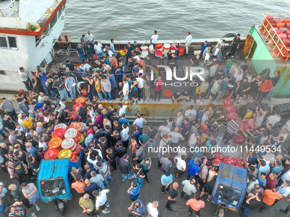 Workers are loading and unloading swimming crabs at the dock of Zhoushan International Aquatic City in Zhoushan, China, on August 2, 2024. 