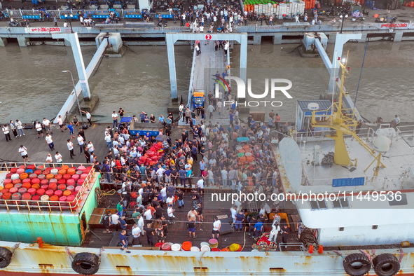 Workers are loading and unloading swimming crabs at the dock of Zhoushan International Aquatic City in Zhoushan, China, on August 2, 2024. 