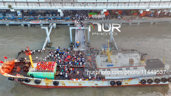 Workers are loading and unloading swimming crabs at the dock of Zhoushan International Aquatic City in Zhoushan, China, on August 2, 2024. 