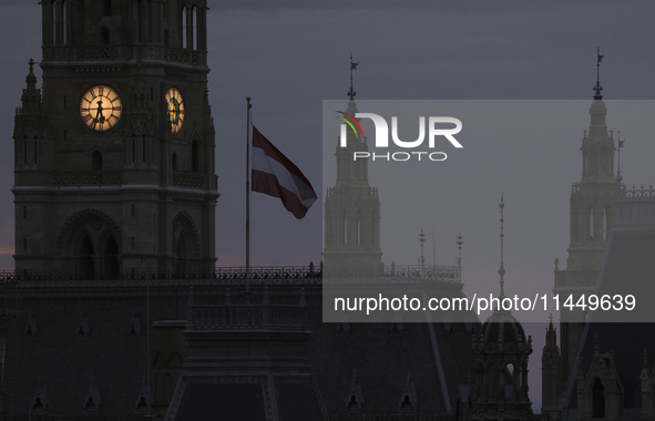 The Austrian national flag flies in front of the Vienna City Hall early in the morning in Vienna. Austria, Friday, August 2, 2024. 