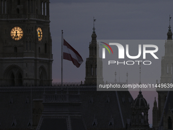 The Austrian national flag flies in front of the Vienna City Hall early in the morning in Vienna. Austria, Friday, August 2, 2024. (