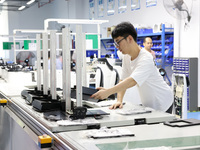 A staff member is assembling intelligent robots at a production line in Fuzhou, China, on August 1, 2024. (