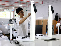 A staff member is assembling intelligent robots at a production line in Fuzhou, China, on August 1, 2024. (