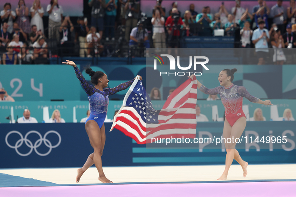 Simone Biles (L) and Sunisa Lee of Team United States celebrate after winning respectively the gold and bronze medal at the end of the Artis...