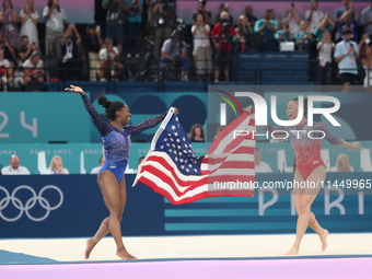 Simone Biles (L) and Sunisa Lee of Team United States celebrate after winning respectively the gold and bronze medal at the end of the Artis...